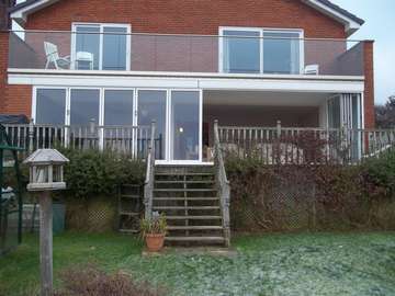 Mr & Mrs H. . CALDY , WIRRAL : Installation of a set of 10m wide S 1000 Aluminium Bi Fold doors double glazed . Marine finsh Polyester Powder Coated Std white . CLL Balastrading glazed with heat- soak 15mm toughened Laminated glass 